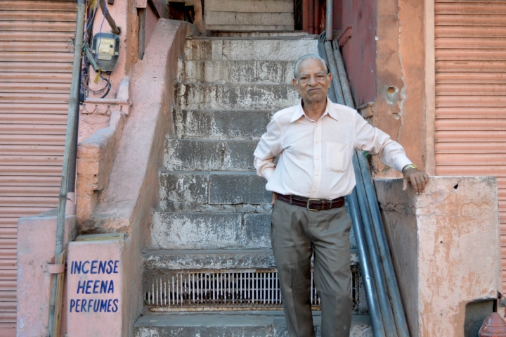 Indien in Bildern Ein Mann steht vor seinem Laden in Jaipur gegenüber dem Palast der Winde