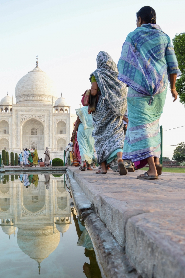 Indien in Bildern Eine Reihe von Frauen in Saris läuft auf das Taj Mahal zu