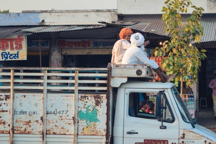 Indien in Bildern Zwei Männer sitzen auf dem Dach eines LKW
